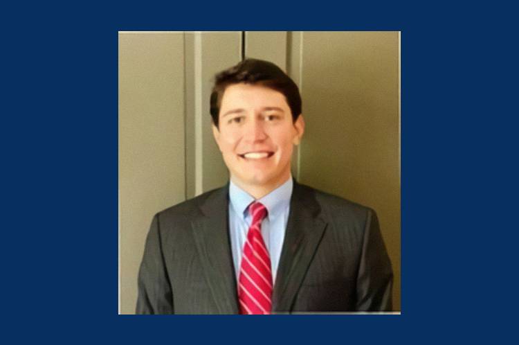 A man in suit and tie smiling for the camera.