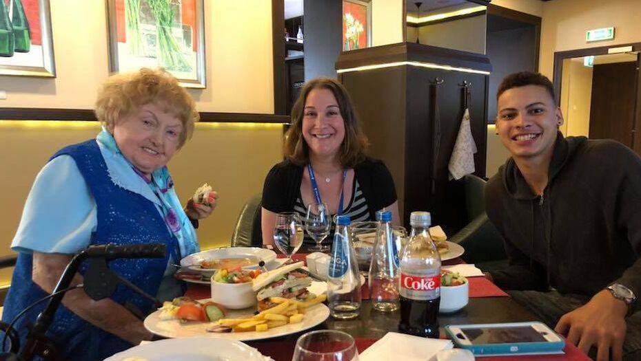 Three women sitting at a table with plates of food.