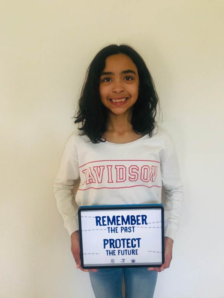 A girl holding up a sign that says " remember the past protect the future ".