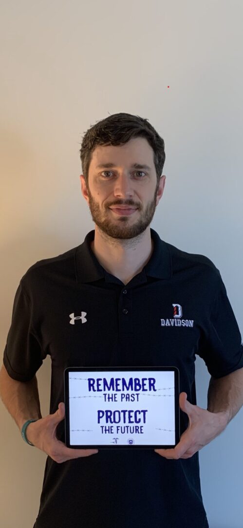 A man holding up a sign that says remember.