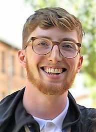 A man with glasses smiling for the camera.