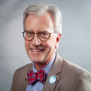 A man with glasses and bow tie in a suit.