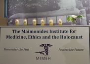 A sign with candles on it that reads " the maimonides institute for medicine, ethics and the holocaust ".