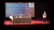 A group of people sitting at a table on stage.