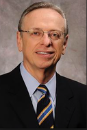 A man in a suit and tie wearing glasses.