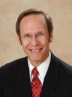 A man in a suit and tie smiling for the camera.