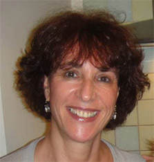 A woman with brown hair and white shirt smiling.