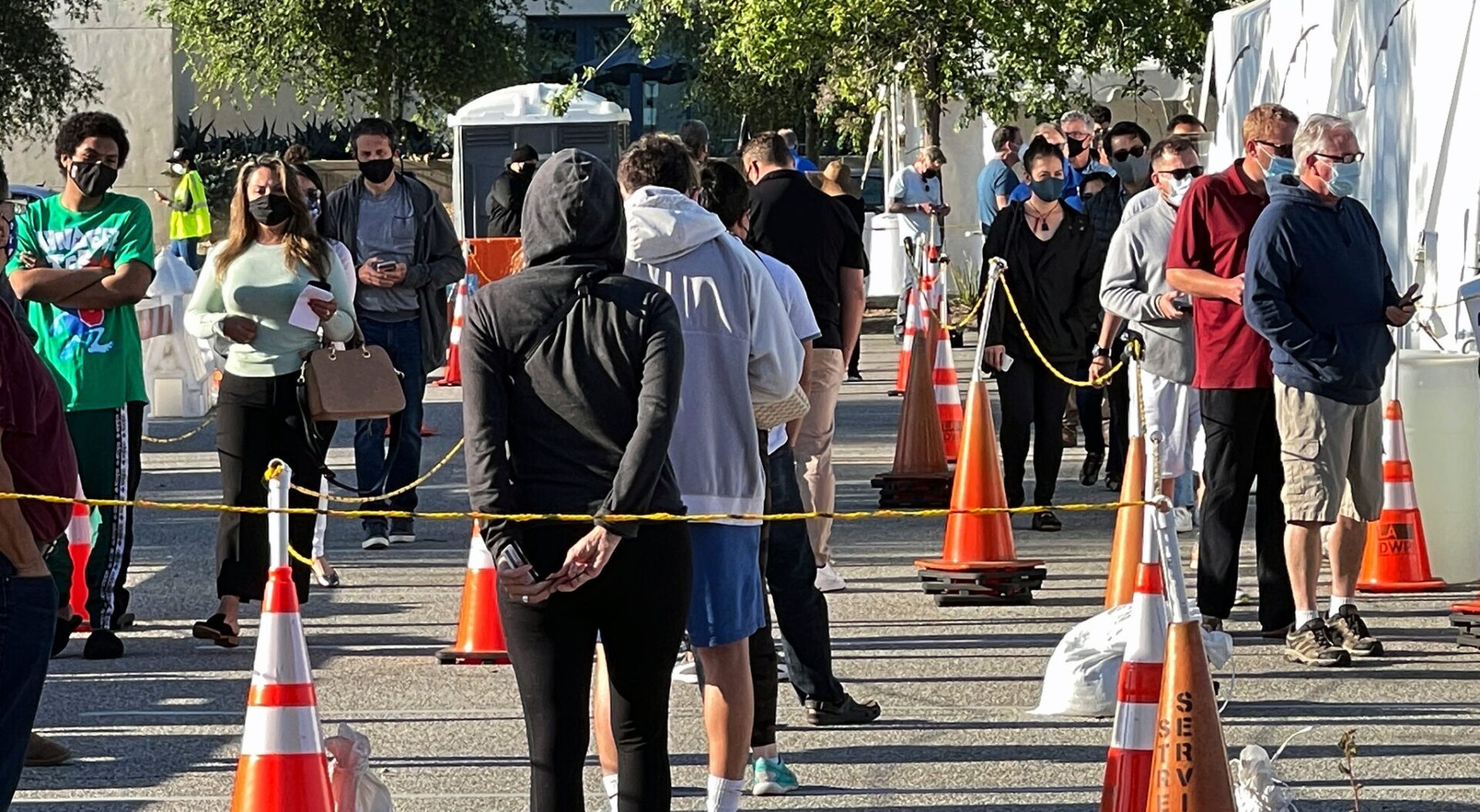 A group of people standing around orange cones.