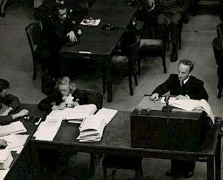 A group of men sitting at tables in an office.